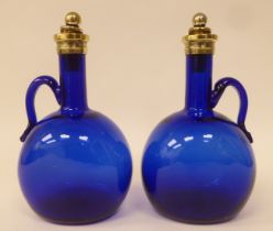 A pair of antique Bristol blue glass decanters of  bulbous form with narrow necks, strap handles,