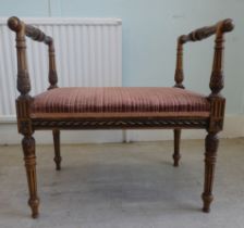 A reproduction of an Edwardian Continental inspired beech framed, fluted and foliage carved stool