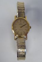 A lady's Omega oval, gold plated/stainless steel cased wristwatch, faced by a baton dial, on a