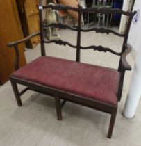 An early 20thC Georgian design, double chair back open arm settee, raised on square