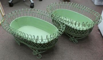 A pair of vintage oval green wirework planters with tinplate liners, elevated on scrolled feet  26"L