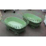 A pair of vintage oval green wirework planters with tinplate liners, elevated on scrolled feet  26"L