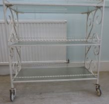 A 1970/80s white painted, cast metal, three tier hostess trolley with glass shelves  34"h  32"w