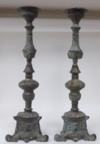 A pair of late 19th/early 20thC patinated green bronze, triform outlined pricket candlesticks with