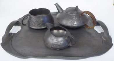 A Liberty & Co Tudric pewter three piece tea set of squat, bulbous form, designed by