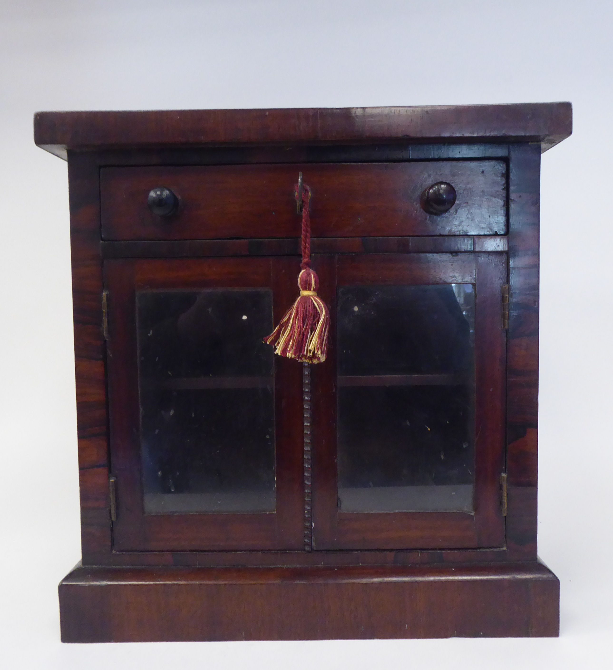 An early Victorian rosewood tabletop collector's cabinet, fashioned as a miniature chiffonier, the