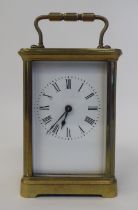 A mid 20thC lacquered brass cased carriage timepiece with bevelled glass panels, a folding top