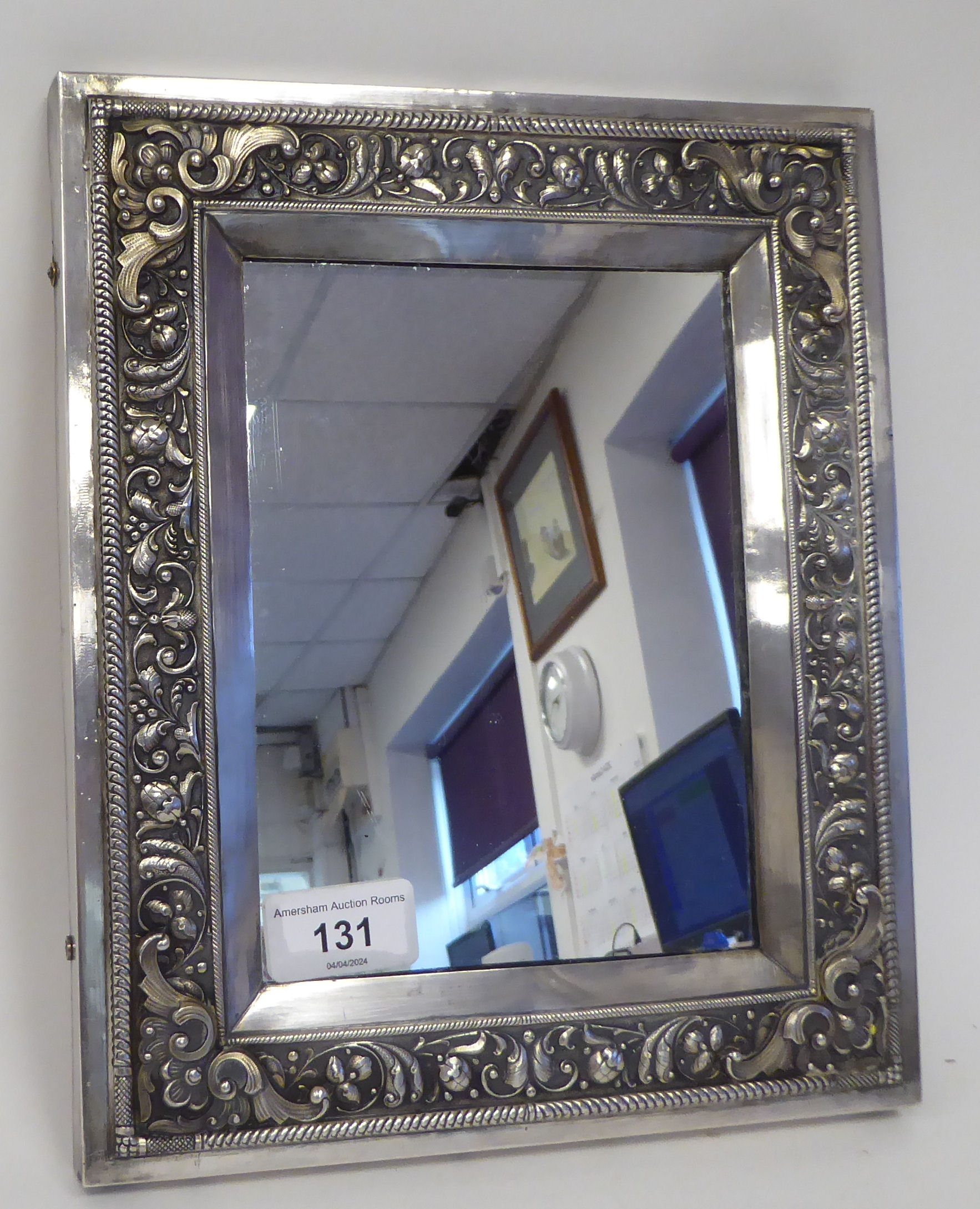 A Russian silver coloured metal icon frame, the mitred wide border decorated