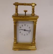 A 20thC lacquered brass cased miniature carriage clock with bevelled glass panels and a folding