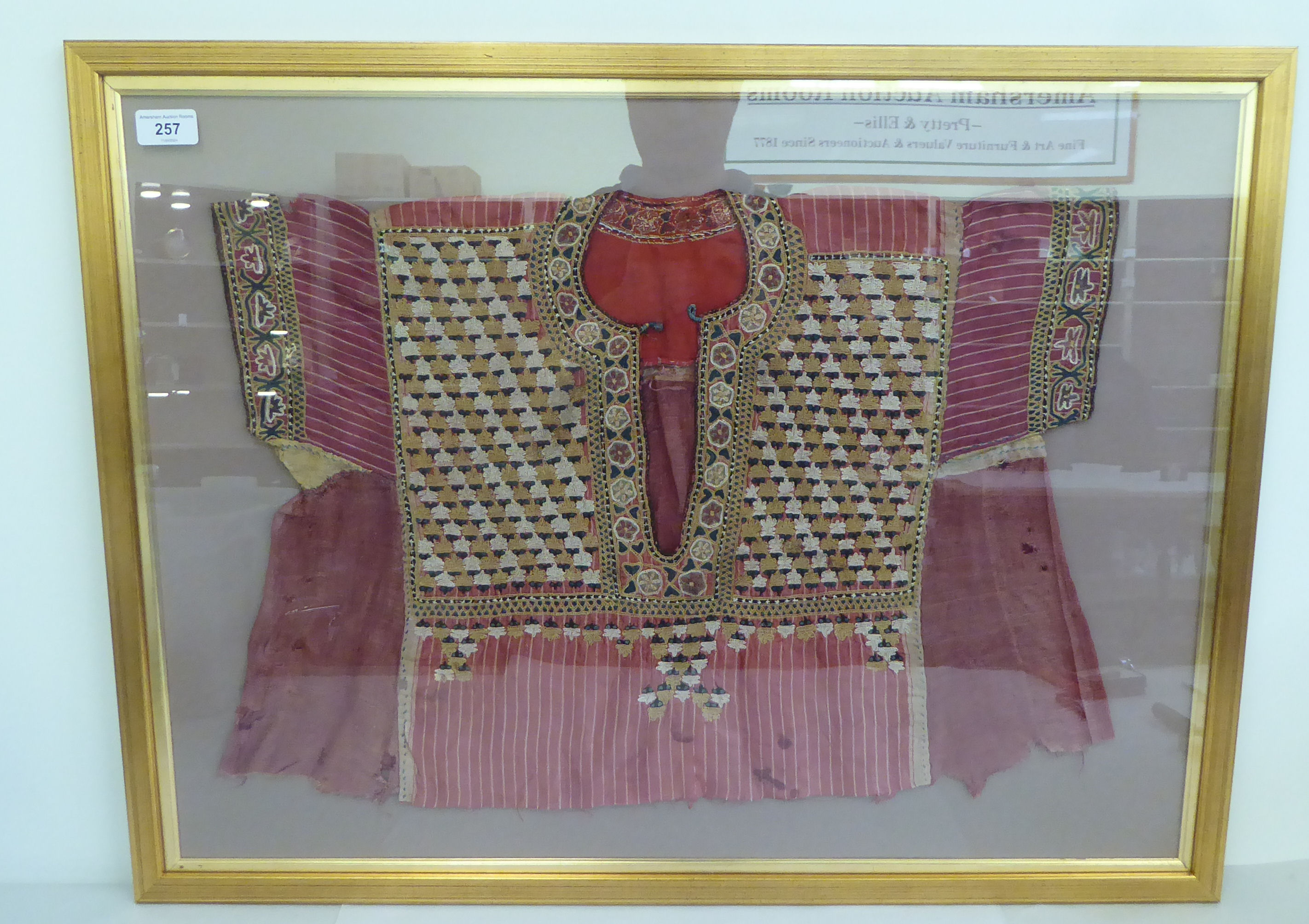 An Asian antique tunic, richly embroidered in colours  16" x 22" overall  framed