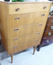 A 1970s teak five drawer tallboy, raised on tapered legs  42"h  27"w