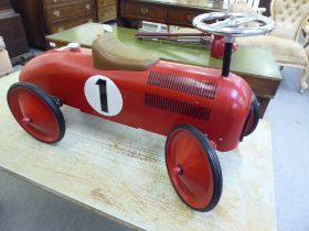 A child's red painted cast metal push-along racing car