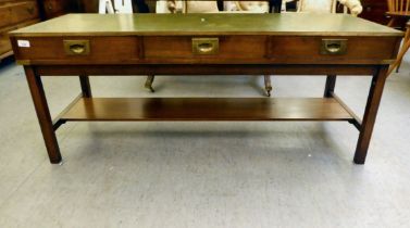 A 20thC low side table with a tooled sage green hide scriber, over three inline drawers with