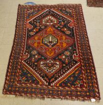 A Persian rug, decorated with floral motifs, on a red and beige ground  60" x 42"