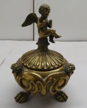 An Art Nouveau cast bronze, desktop inkwell with a cut glass liner and cover, incorporating a seated