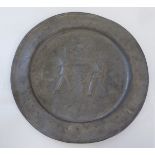 An antique broad rimmed pewter charger, decorated with two figures working in a vineyard  12"dia