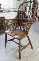 A late 18thC ash and elm high hoop back Windsor chair with a solid seat, raised on turned, tapered