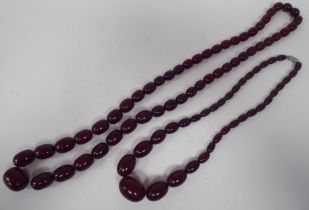 Two semi-transparent deep red coloured bead necklaces