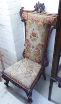 A late Victorian walnut framed prie-dieu with a floral tapestry panelled back and a cushioned