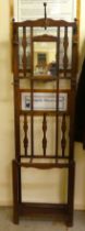 A 1930s oak hallstand with a central mirror and scrolled hooks  73"h  23"w