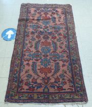 A Persian woollen rug, decorated in sombre colours, on an iron red ground  72" x 48"