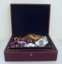 Costume jewellery: to include a paste set brooch; and bead necklaces, in a fabric lined and tooled