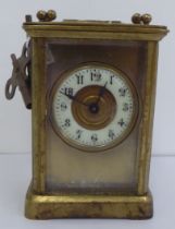 A mid 20thC brass cased carriage timepiece with bevelled glass panels and a visible escapement;