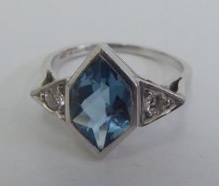 A white metal ring, set with a central aquamarine, flanked by two diamonds  stamped 950