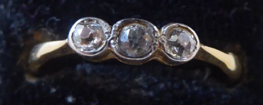 An 18ct gold three stone, rubover set diamond ring