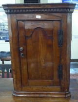 A George III walnut hanging corner cabinet with a single door  35"h  25"w