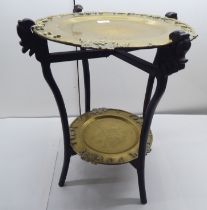 A 20thC Chinese fruitwood framed table with two removeable lacquered brass trays, engraved with