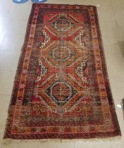 A Persian design rug with central stylised motifs, on a red ground  78" x 40"