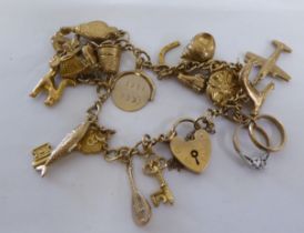 A 9ct gold charm bracelet, on a padlock clasp