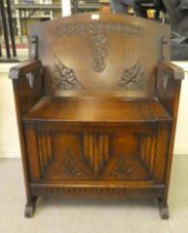 A mid 20thC carved oak monks bench, over a covered box seat  27"w