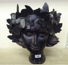 A black painted composition novelty planter, fashioned as a girl wearing a crown of butterflies