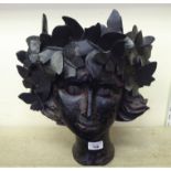 A black painted composition novelty planter, fashioned as a girl wearing a crown of butterflies