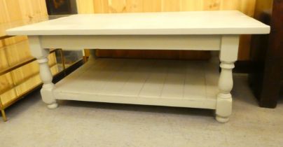 A modern grey painted pine coffee table, raised on turned legs, united by an undershelf, on bun feet