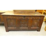 A late 18thC oak coffer with straight sides and a hinged lid, over a tri-panelled and carved