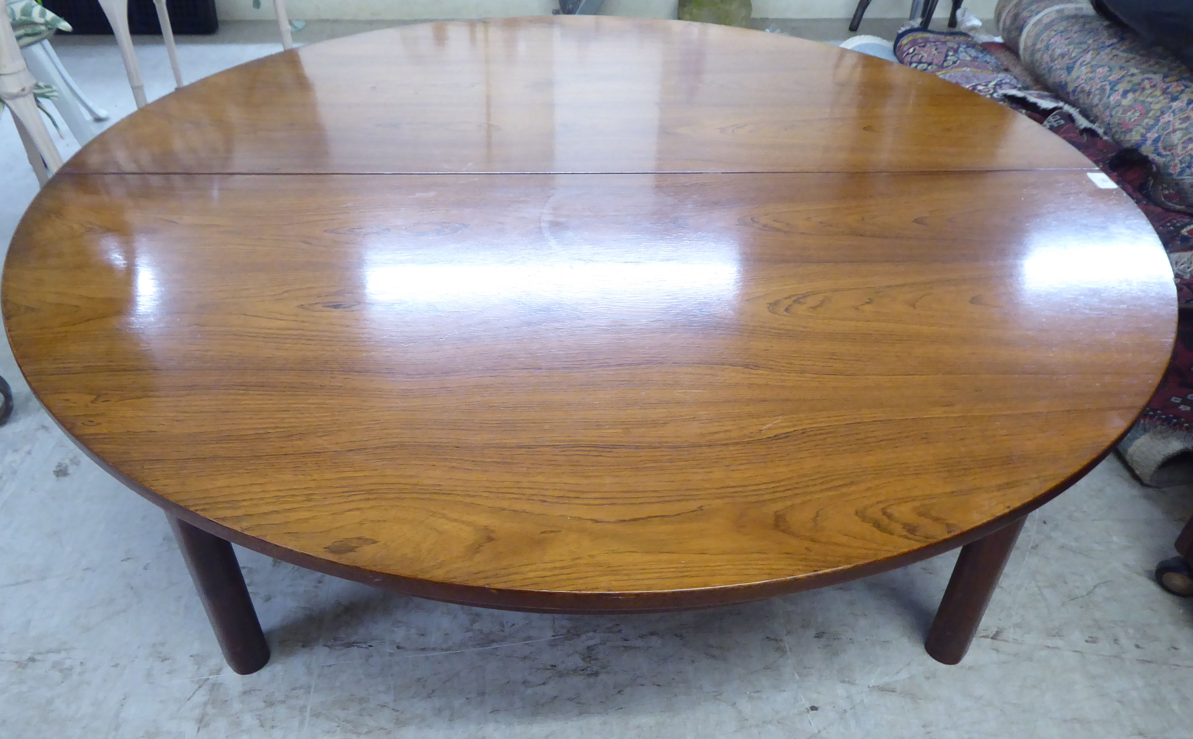 An AH McIntosh & Co teak extending coffee table  15"h  46"dia  extending to 64"dia with an