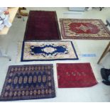 Five rugs: to include a Persian example, on a multi-coloured ground  48" x 64"