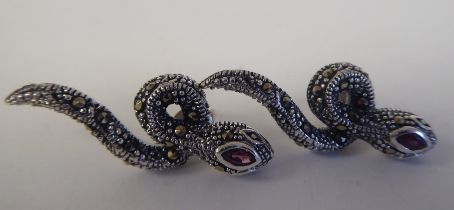 A pair of silver coloured metal and marcasite, snake design earrings with ruby eyes