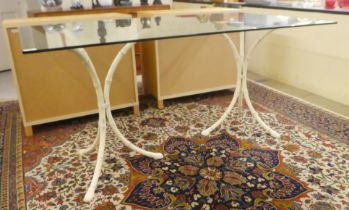 A modern table, the plate glass top on two cream painted bamboo effect, cast metal tripods  29"h