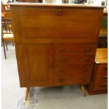 An Ercol stained elm cabinet, incorporating a fall front, over an arrangement of four drawers and