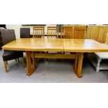 A modern light oak dining table, the top with bowed sides, raised on planked legs, united by a