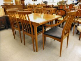 A 1960s/70s teak dining suite, comprising a draw leaf table, raised on square, tapered legs; and a