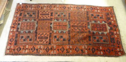 A Turkoman rug with repeating panel designs, on a red ground  47" x 82"