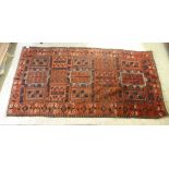 A Turkoman rug with repeating panel designs, on a red ground  47" x 82"