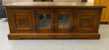 A Wood Bros Lancaster oak television stand, comprising two glazed cupboard doors and two drawers,