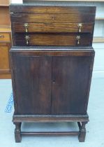 A 1930s oak canteen with a hinged lid, two drawers and a cabinet below  41"h  20"w; and silver