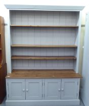 A modern grey painted and honey coloured pine two-part dresser, the superstructure with three height